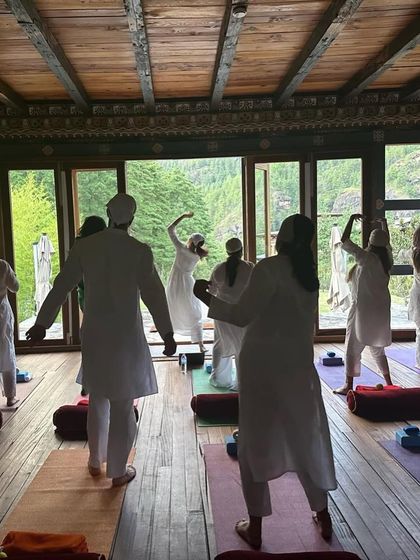 A Mahashivratri class held in Goa. The image captures the energy of celebration through dance-like movements in a beautiful, rustic hall overlooking lush greenery.
