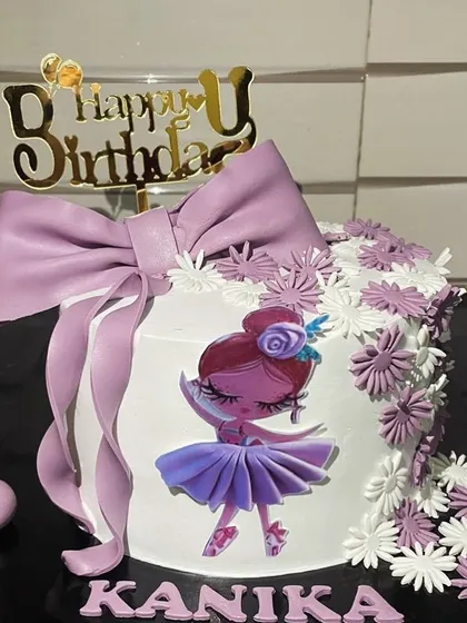 For a little dancer, this ballerina-themed cake is a perfect choice. It features a beautiful edible ballerina illustration, delicate purple flowers, and a large, handcrafted fondant bow for an elegant and sweet touch.