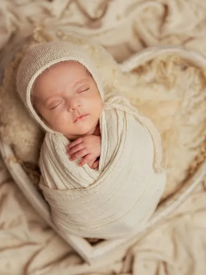 Wrapped in love, safe and sound. This classic pose in a heart-shaped basket is a timeless way to capture your newborn. I use soft, neutral-toned wraps and textures to keep the focus entirely on your baby's peaceful expression.