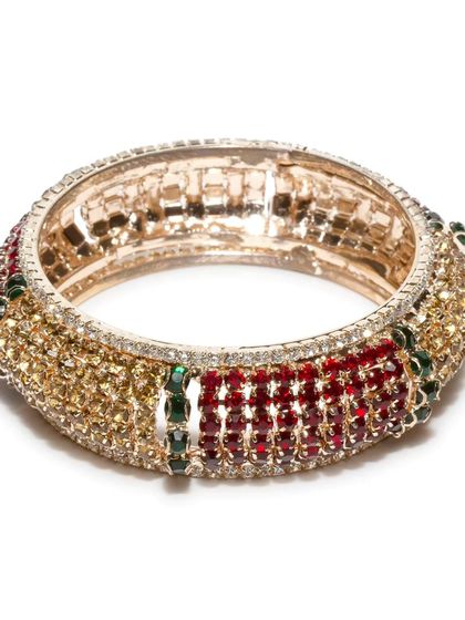 A beautiful stone-studded kada bangle in red, green, and gold. This broad bangle is perfect for adding a touch of royalty to your wrist.