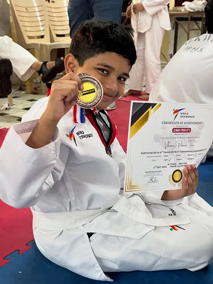 Another one of our little warriors proudly showing off his medal and certificate.