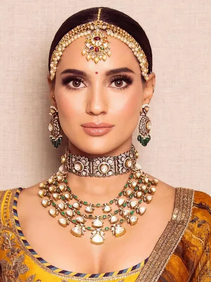 A full-face portrait of the mustard yellow bridal look. The makeup is balanced and harmonious, creating a look that is both traditional and fresh.