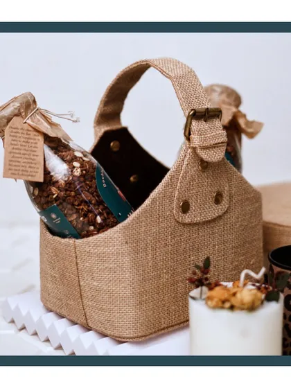 This rustic jute basket holds a bottle of my homemade granola, a perfect example of my 'Blessings by Bombay Hampers' wellness collection.