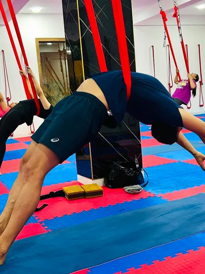 Supported backbends in the aerial hammock allow for a deeper opening of the chest and shoulders without straining the lower back.