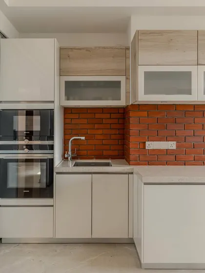 A look at the integrated appliance tower in Hina Gandhi's Ahmedabad kitchen. The stacked Siemens ovens are framed by high-gloss lacquer cabinetry, demonstrating how we blend high-performance technology into our designs.