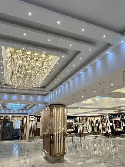 Another photo of the Grand Utsav Banquet during its final setup stages. The magnificent crystal chandeliers are a key feature of this premium hall.