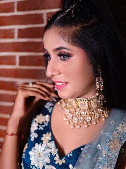 A close-up profile of a client ready for her engagement. This highlights the glamorous eye makeup and the intricate choker necklace.