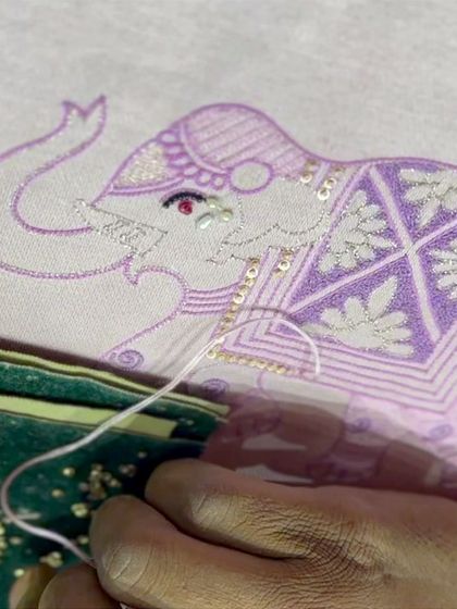 A gentle giant takes form, one delicate stitch at a time. This close-up shows our artisan hand-embroidering an elephant motif, a favorite among our clients for its playful and regal symbolism.