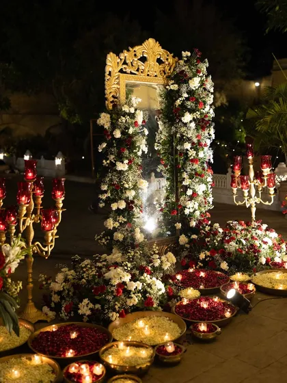 A grand floral and mirror installation for the Sangeet, combining red and white flowers with ornate golden frames for a luxurious photo backdrop.