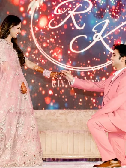 A classic proposal moment on stage, as the groom kneels before his bride. The floral arch and sparkling backdrop add to the romance of this milestone, marking the official start of their journey together.