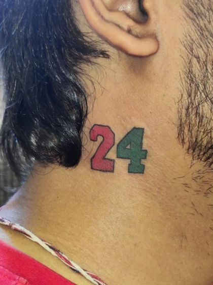 Another number tattoo on the neck, this time "24." These small, colorful number tattoos are a subtle nod to a favorite player or a lucky number.