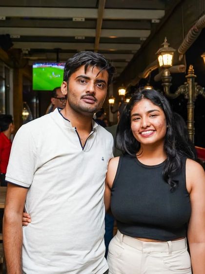 Guests posing for a photo during a night out. In the background, you can see one of the screens that are placed throughout the venue, ensuring you don't miss any of the live sports action.