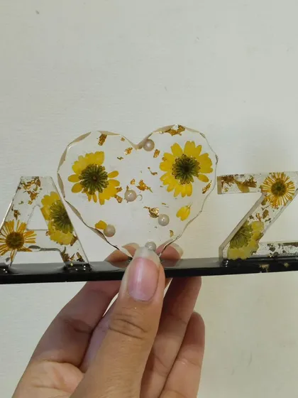 Holding the 'A heart Z' initial frame to show its size and the details of the embedded flowers.