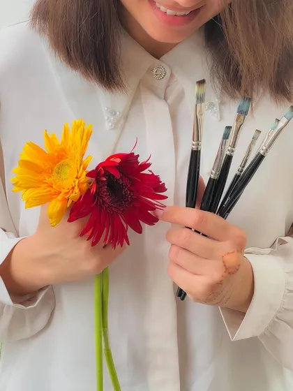 Holding my brushes and flowers. These are the simple things that bring me joy and fuel my creativity.