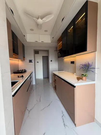 The full view of the rose gold kitchen, showing the clean, uncluttered layout and marble-finish flooring. The parallel counters provide ample workspace for a busy kitchen.