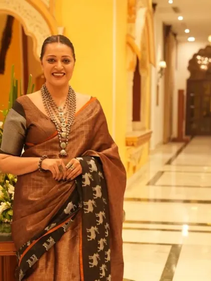 A full-length view of the elephant print saree. The combination of the earthy brown linen and the bold silver jewelry is a great example of modern ethnic styling.