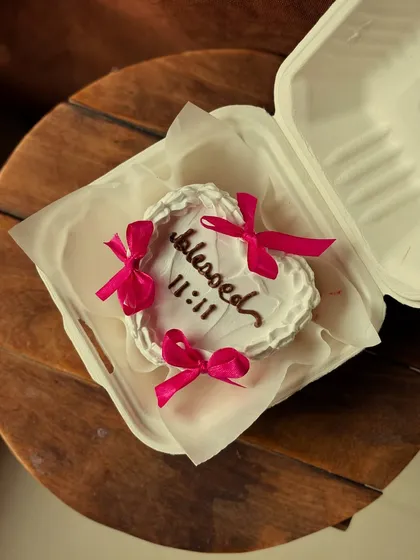 This heart-shaped bento cake with "blessed 11:11" and pretty pink bows is perfect for birthdays or just celebrating a moment of gratitude.