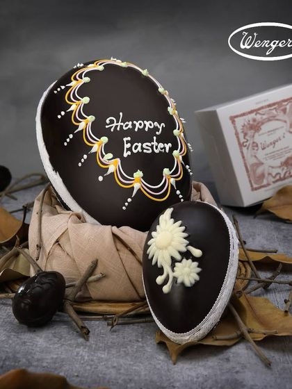 A large, intricately decorated dark chocolate Easter egg, with "Happy Easter" piped by hand. It’s a stunning centerpiece for your Easter celebration.