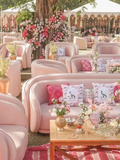 The sprawling outdoor setup, with rows of elegant pink sofas and tents in the background, showcasing the grand scale of the celebration.