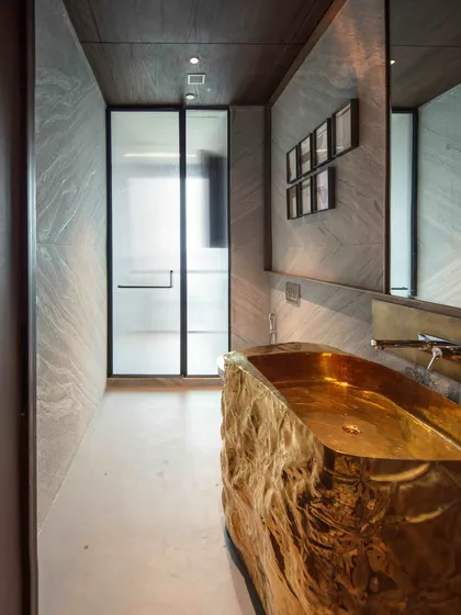 Detail from a powder room in 'The 42, Kolkata', featuring a custom-designed washbasin console crafted from a single piece of brass. This piece demonstrates our approach to making even the most functional items into objects of art and luxury.