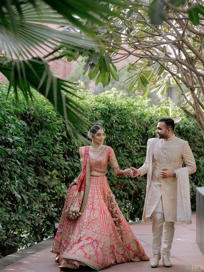 A fairytale moment. The couple takes a romantic walk hand-in-hand through the venue's gardens, looking like a king and queen.