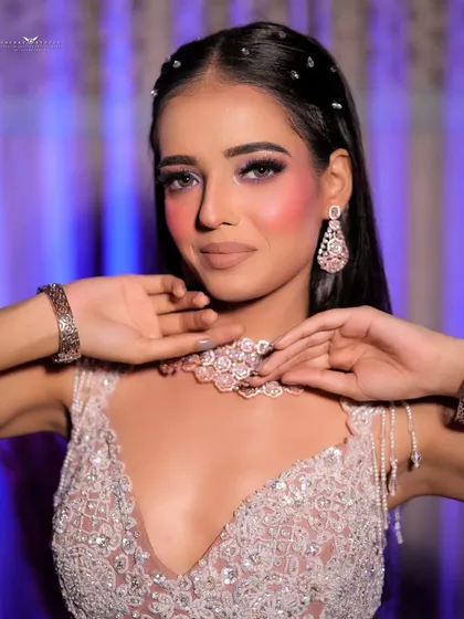 A close-up shot focusing on the sparkling necklace and the model's engaging expression.