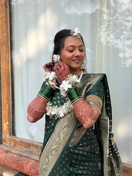 A close-up of the bride adjusting her floral earrings.