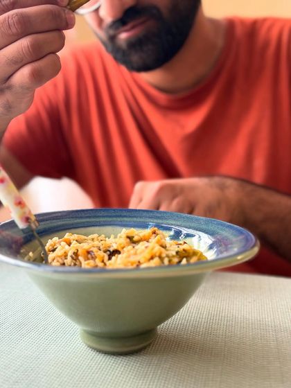 Mahanth enjoying a meal from one of his own creations. This elevated bowl features a beautiful combination of glazes.