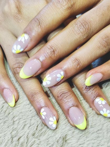 A sweet and cheerful design combining a pastel yellow French tip with accent nails featuring hand-painted daisies. A perfect look for spring and summer.