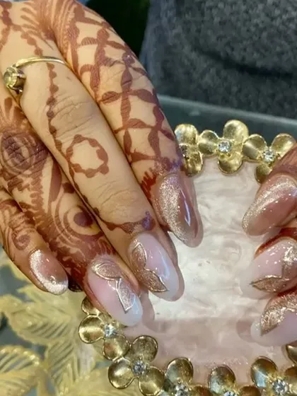 A close-up view of these elegant nails with a subtle cat eye base and intricate gold leaf detailing.