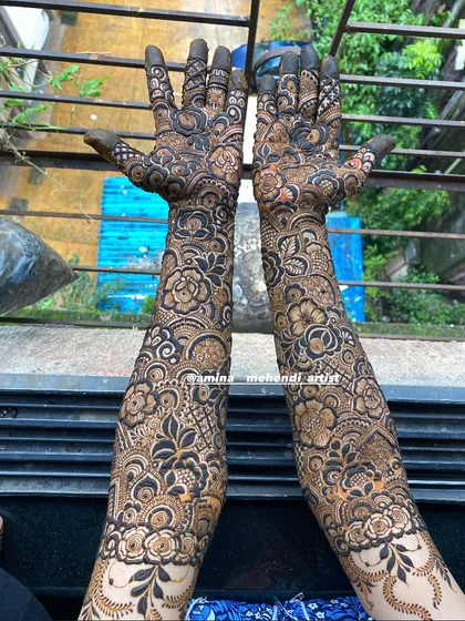 A stunning outdoor shot that captures the intricate details of this full-arm floral mehendi design.
