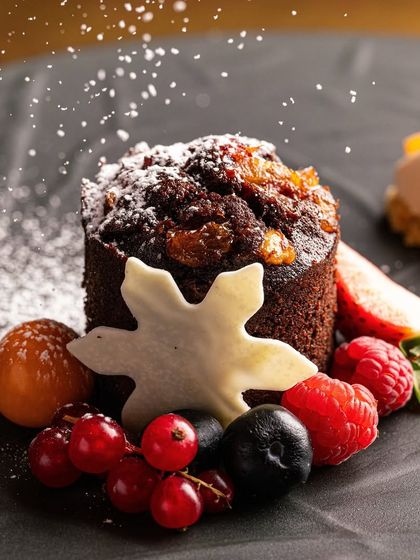 Our Kashmiri dried spice pudding with whiskey ice cream, the grand finale of our Christmas feast. It’s a warm, festive dessert adorned with winter berries.