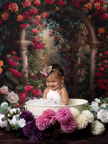 Splash time! This action shot captures the fun of a milk bath session, with water splashing and a big smile on her face.