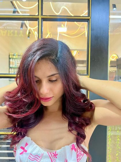 A beautiful shot of the finished red hair makeover. The color is rich and multi-tonal, and the soft curls add a touch of glamour and sophistication.