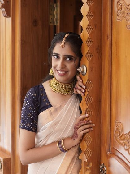Our gorgeous client Rashmi Nair looks serene and beautiful in a simple white saree and a traditional temple choker. A perfect example of understated elegance.