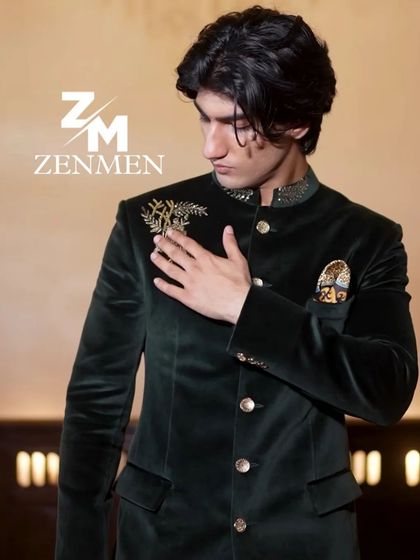 A close-up of the model's hand on the emerald velvet bandhgala, drawing attention to the fine gold embroidery and luxurious fabric.