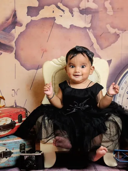 A happy little traveler ready for her next adventure. The vintage props and map backdrop create a wonderfully imaginative setting for a sitter session.