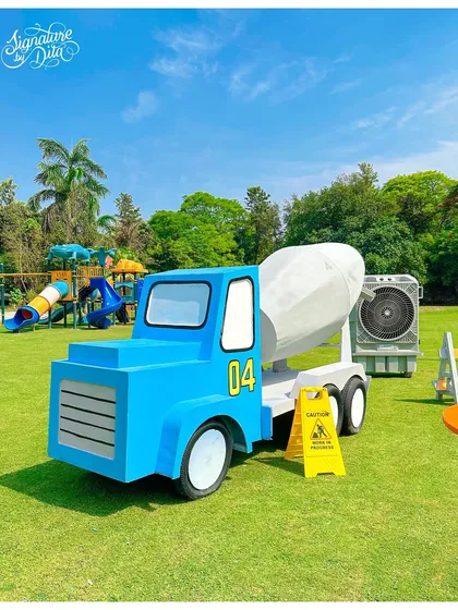 A large, custom-built cement mixer truck prop, adding a playful and impressive element to the outdoor construction site theme.