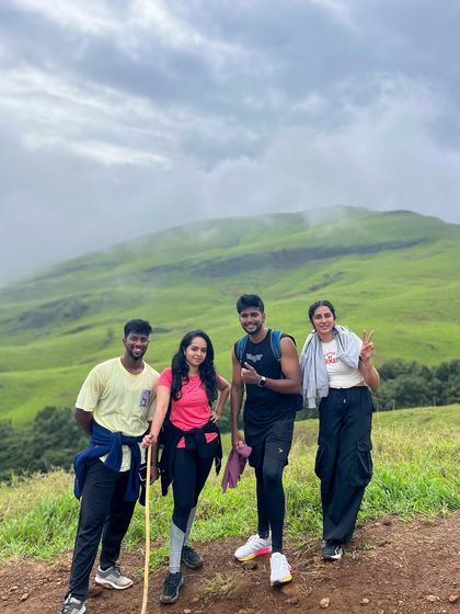 A group of friends posing on the trail, with one using a stick as a prop, capturing the fun spirit of the trek.