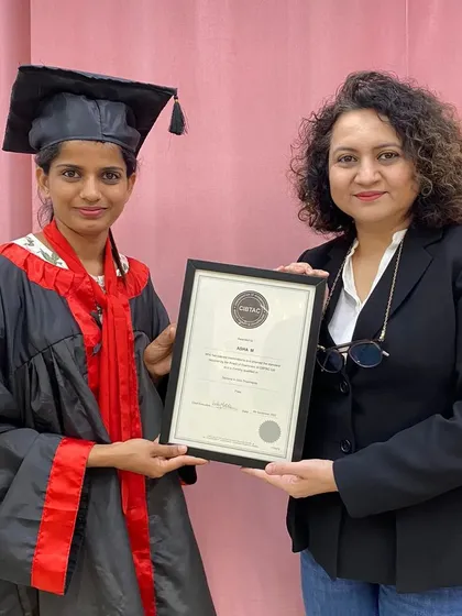 An instructor presenting a newly certified graduate with her framed CIBTAC diploma. We take pride in formally recognizing the dedication and success of our students.
