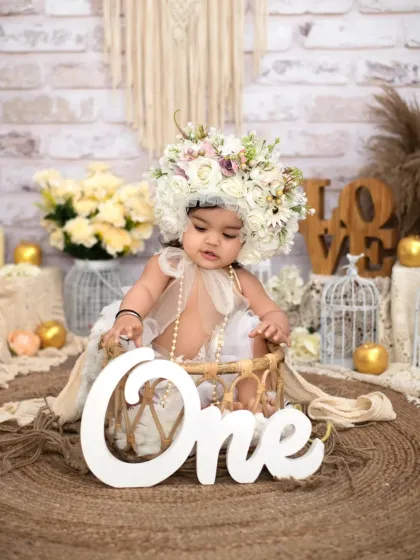A bohemian dream for her first birthday. This beautiful setup features a stunning floral headpiece, a rustic jute rug, and soft, neutral tones to create an artistic and timeless milestone portrait.