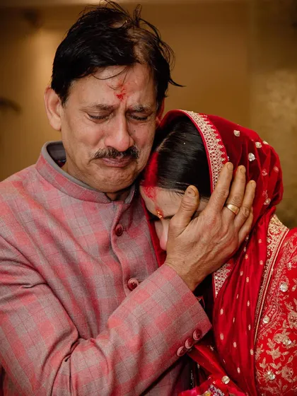 A deeply emotional and candid moment between a bride and her father, capturing the bittersweet tears of a Vidaai ceremony.