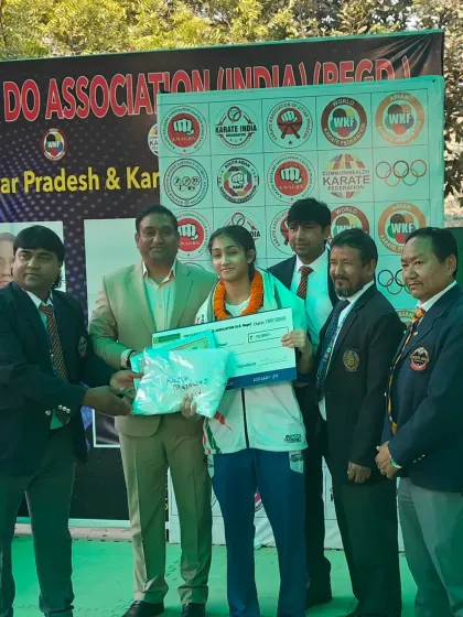 A senior female athlete receiving her prize after a successful district selection tournament.