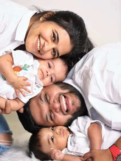 A fun and creative family portrait with twin babies. This playful pile-up is a great way to get everyone close and capture genuine smiles and laughter.