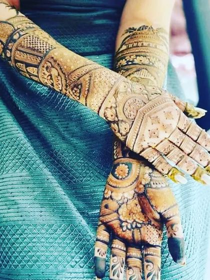 A stylish shot of a bride's mehndi, showing how the intricate patterns wrap around the hands and arms.