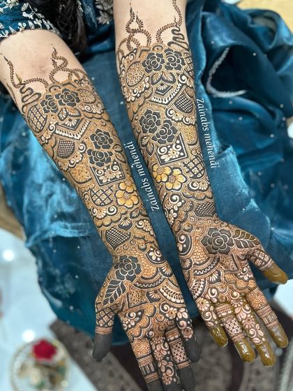 A beautiful example of Pakistani bridal henna for Rabiya, with both hands adorned in a rich, symmetrical pattern.