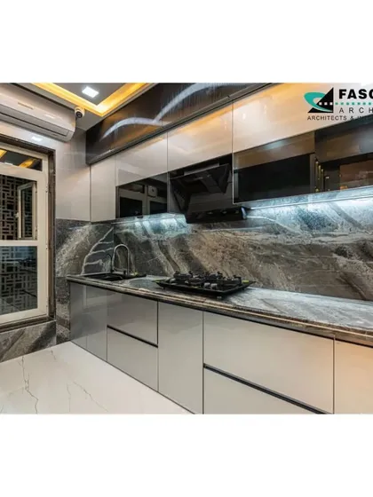 A sleek and functional modular kitchen we designed for a residence in Seawoods. The space features high-gloss grey cabinets, a dramatic marble-patterned backsplash, and integrated under-cabinet lighting for a bright, efficient workspace. Every element is chosen for its durability and timeless aesthetic.