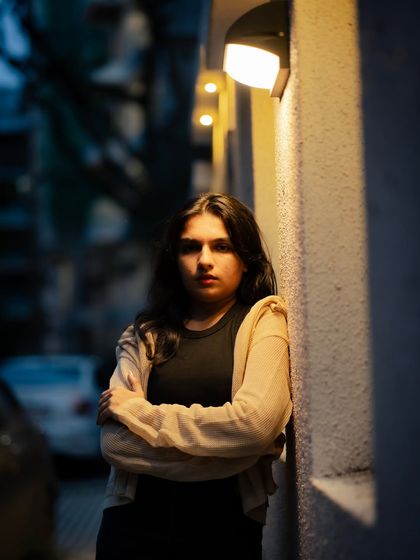 A strong, direct-to-camera pose. The lighting and composition give this portrait a sense of confidence and power.