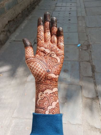 This is a full bridal mehendi I practiced on myself, inspired by one of my favorite artists. It features cloud-like swirls, intricate netting, and varied finger designs, covering the hand and arm completely.