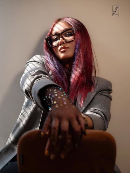 A similar shot with a slightly different angle, emphasizing the dramatic effect of the lighting and the model's confident expression.